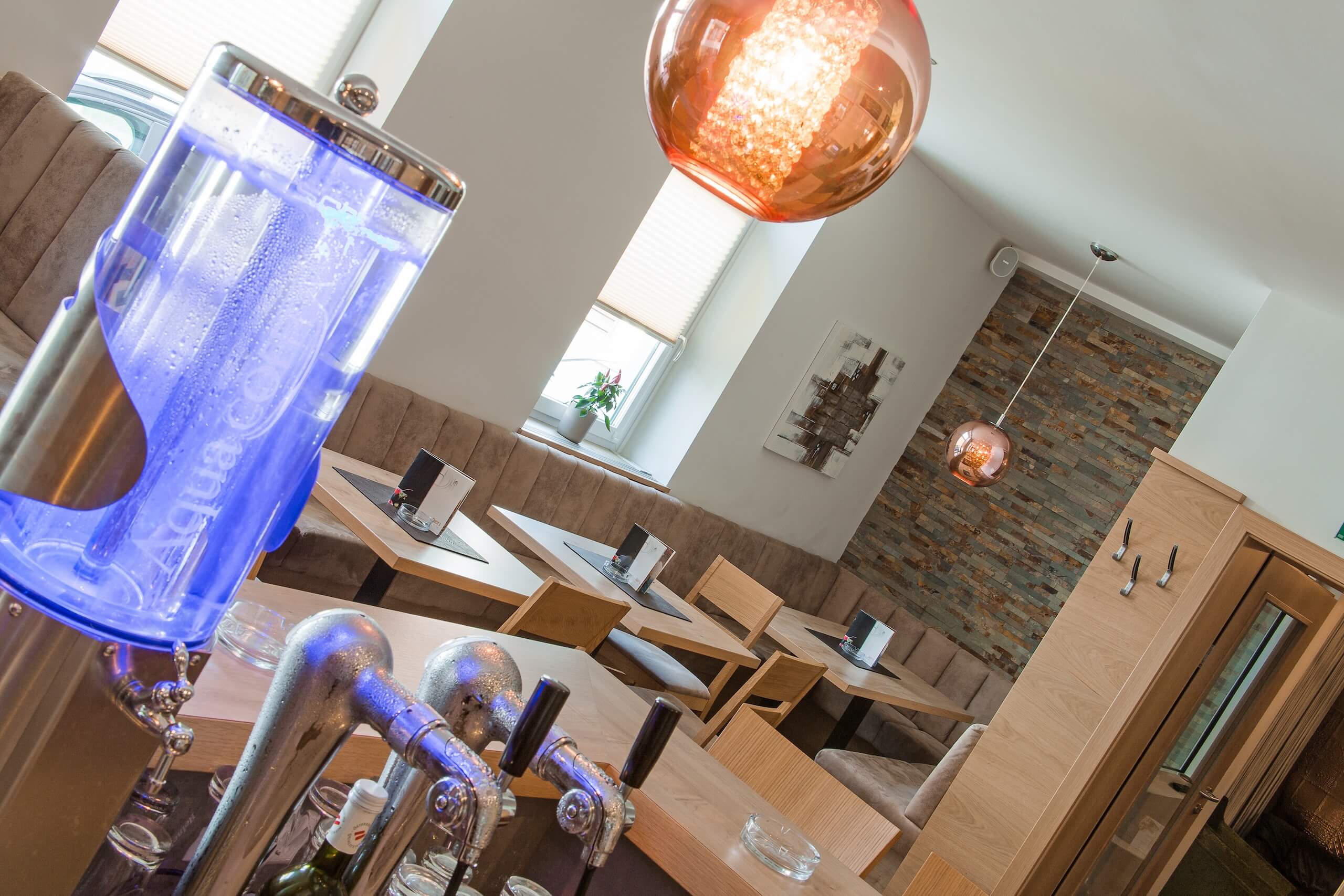 Moderne Café-Inneneinrichtung mit stilvollen Lampen und gemütlichen Sitzbereichen, ideal zum Entspannen und Genießen.