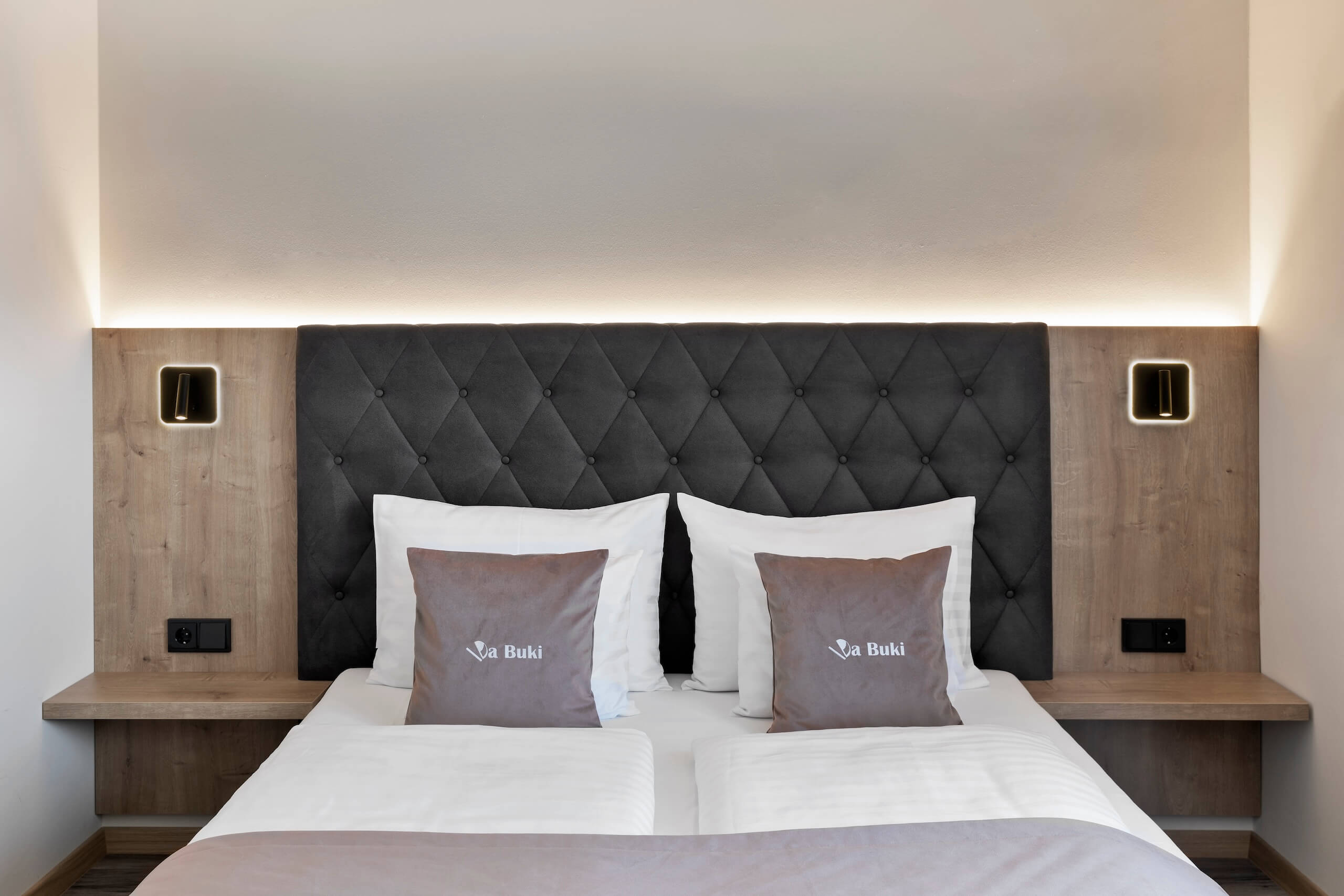 Modernes Hotelzimmer mit einem stilvollen Doppelbett und eleganten Kopfkissen für Komfort und Entspannung.
