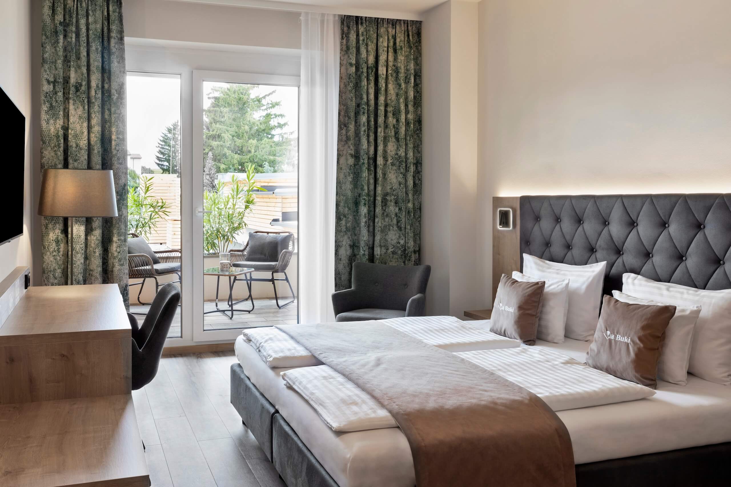 Modernes Hotelzimmer mit Doppelbett, Balkonblick und stilvolle Einrichtung für komfortablen Aufenthalt.