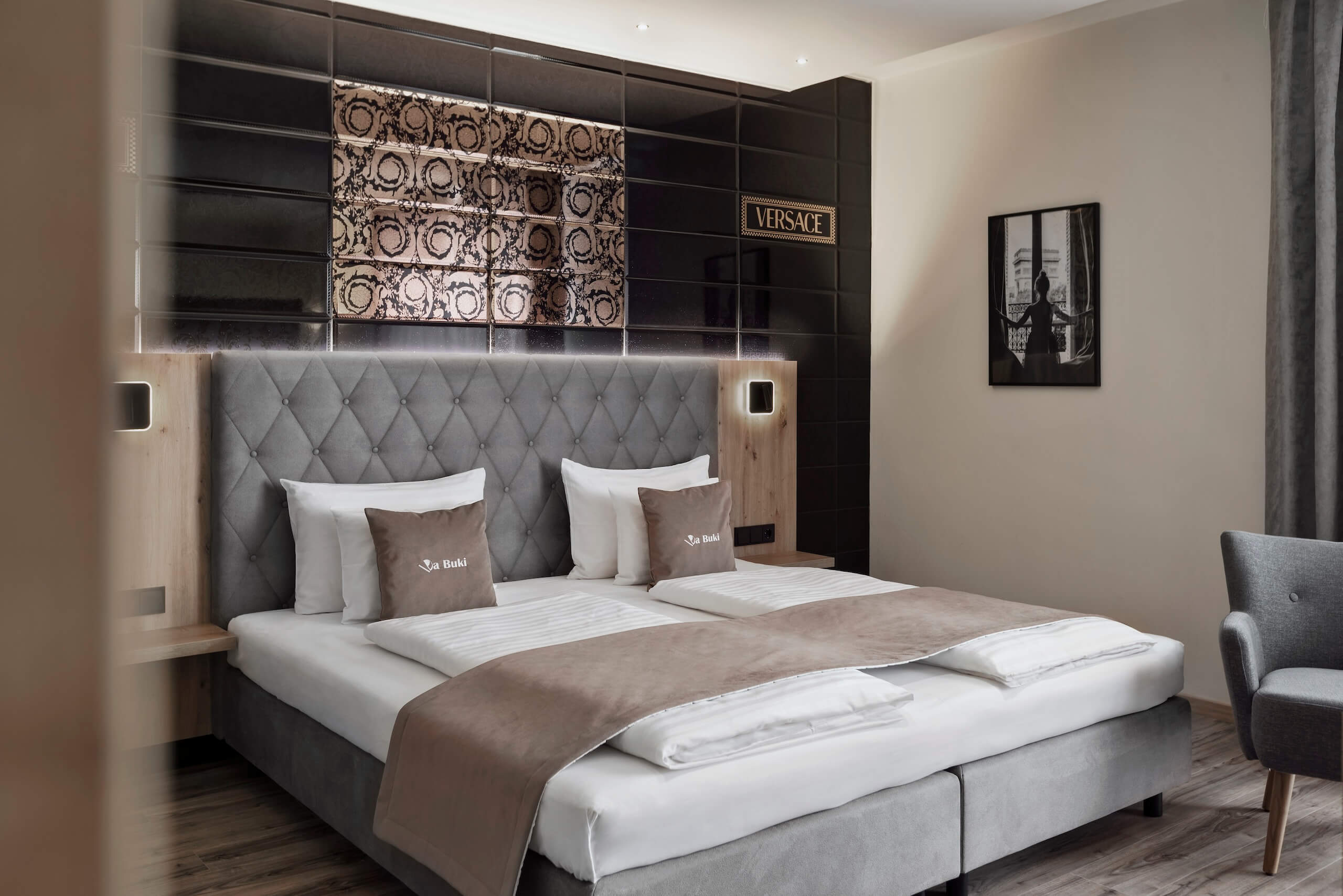 Modernes Hotelzimmer mit stilvollem Doppelbett, eleganter Wandkunst und gemütlichem Ambiente.