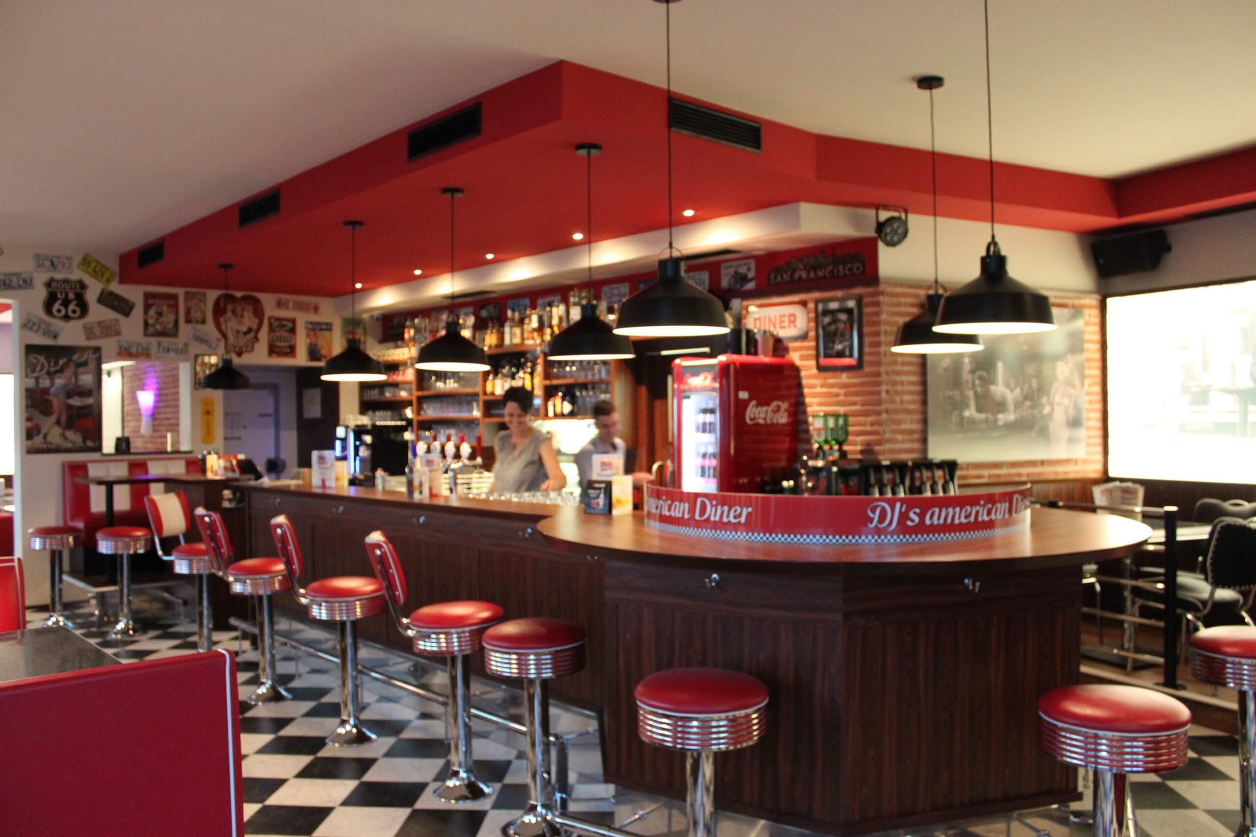 Amerikanisches Diner-Design mit rotem Interieur, Barhockern und Retro-Details für authentisches Vintage-Ambiente.