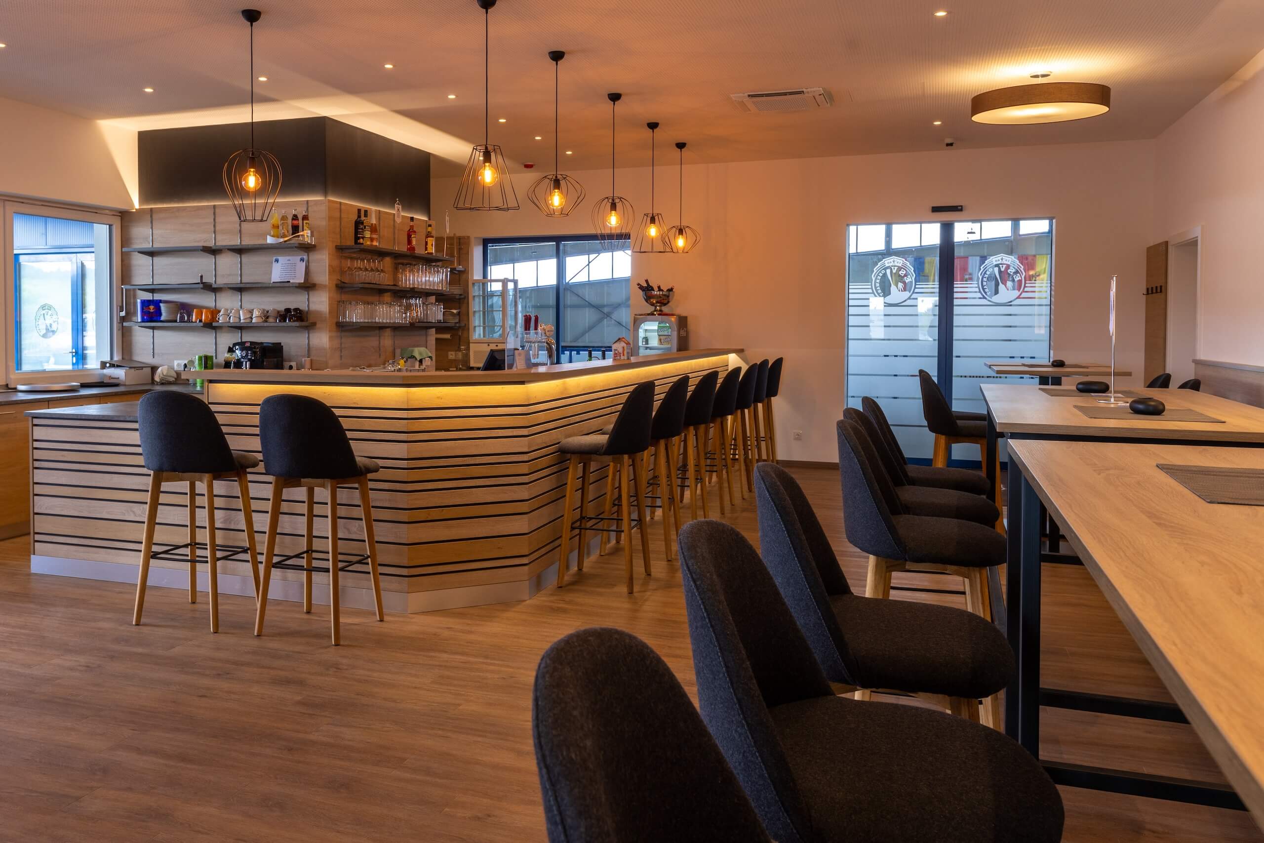 Moderne Lounge-Bar mit gemütlichen Sitzplätzen und stilvollen Lampen für entspannte Abende.