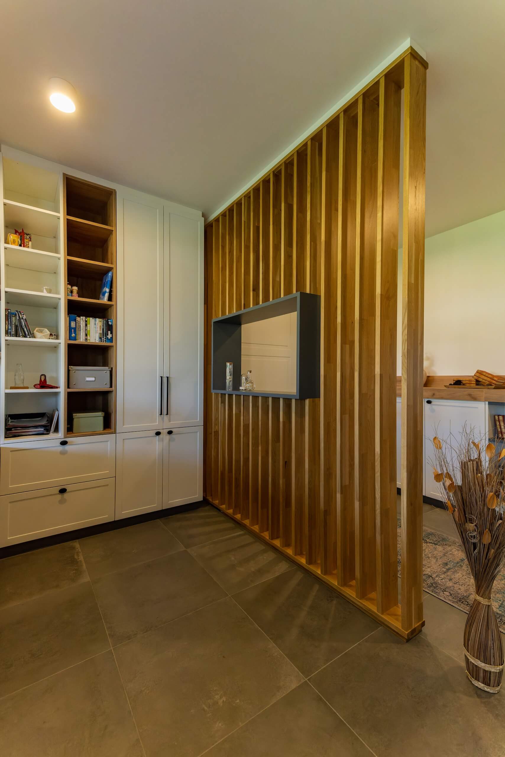 Moderne Wohnzimmerecke mit Holzvertäfelung und integriertem Regal für stilvolle Dekoration.