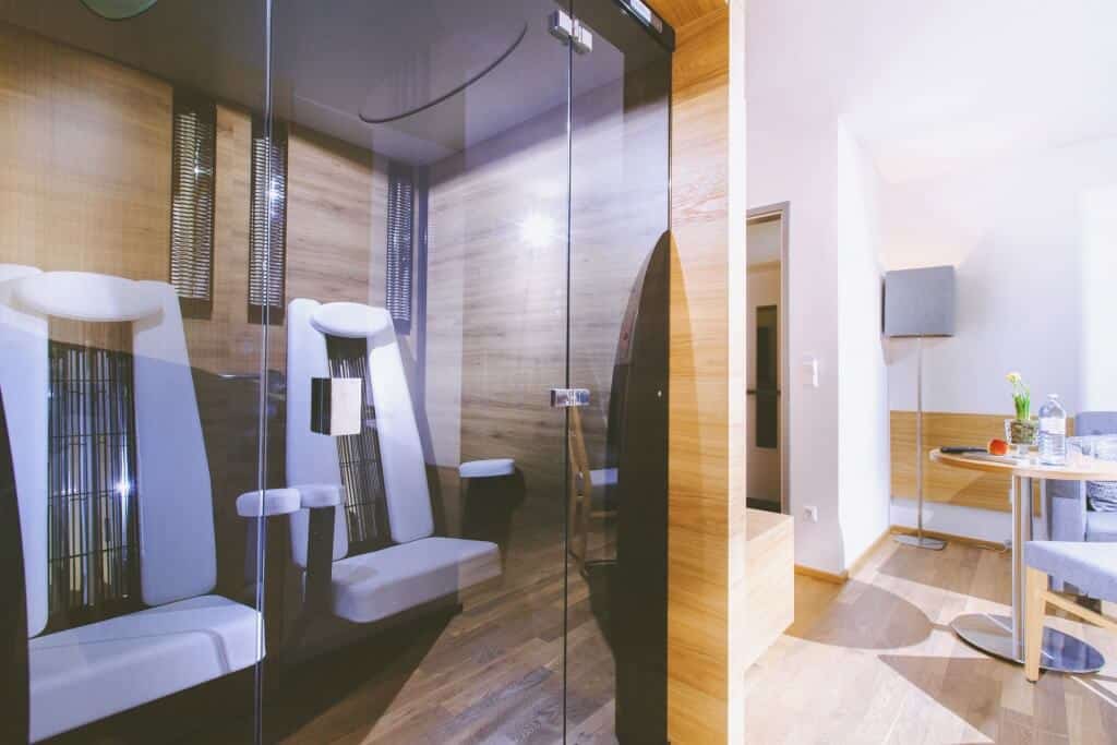 Moderne Infrarotkabine mit eleganter Holzausstattung in einem hellen SPA-Raum für entspannende Wellness-Momente.