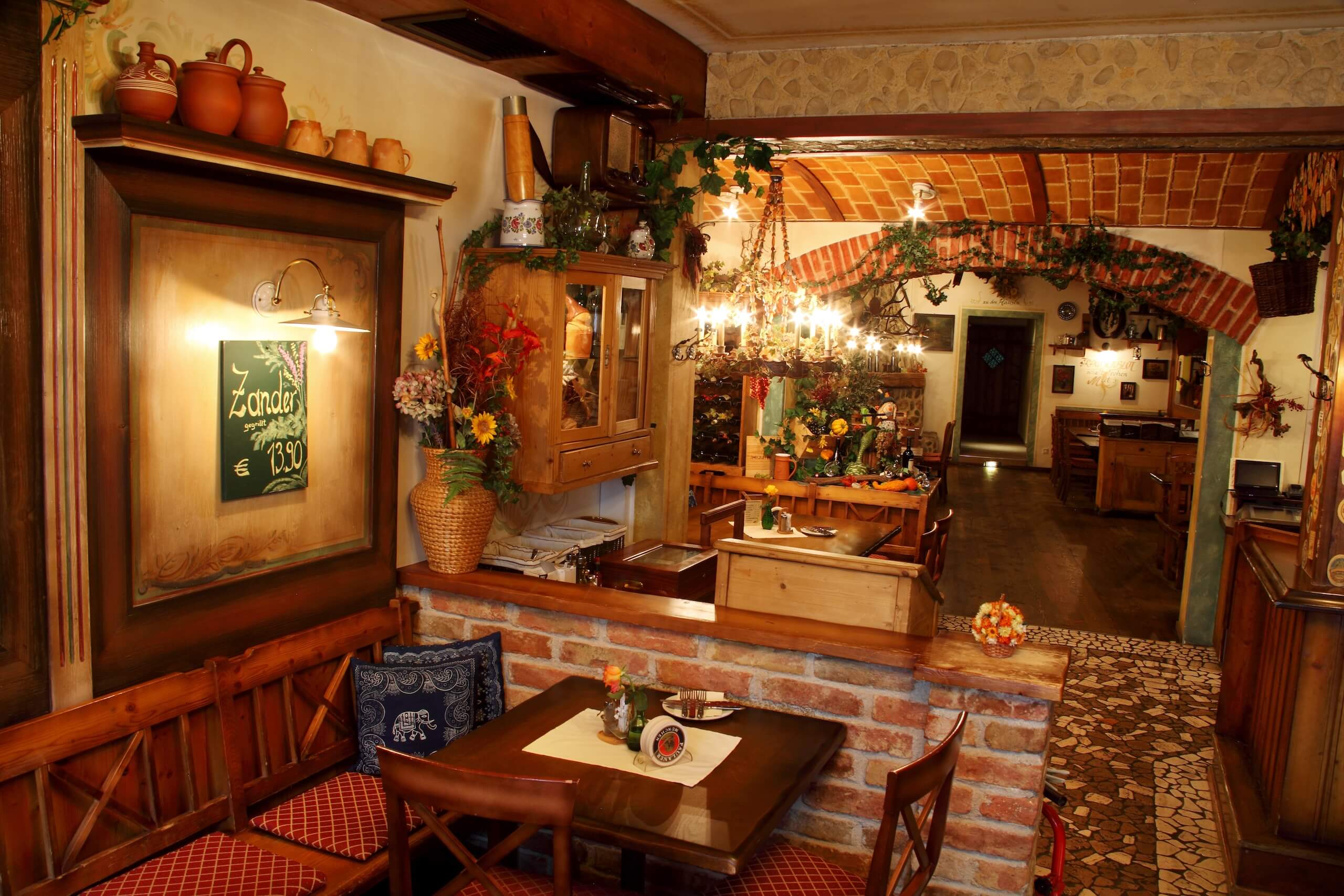 Gemütliches Restaurant im Landhausstil mit rustikaler Dekoration, Holzmöbeln und einer einladenden, warmen Atmosphäre.