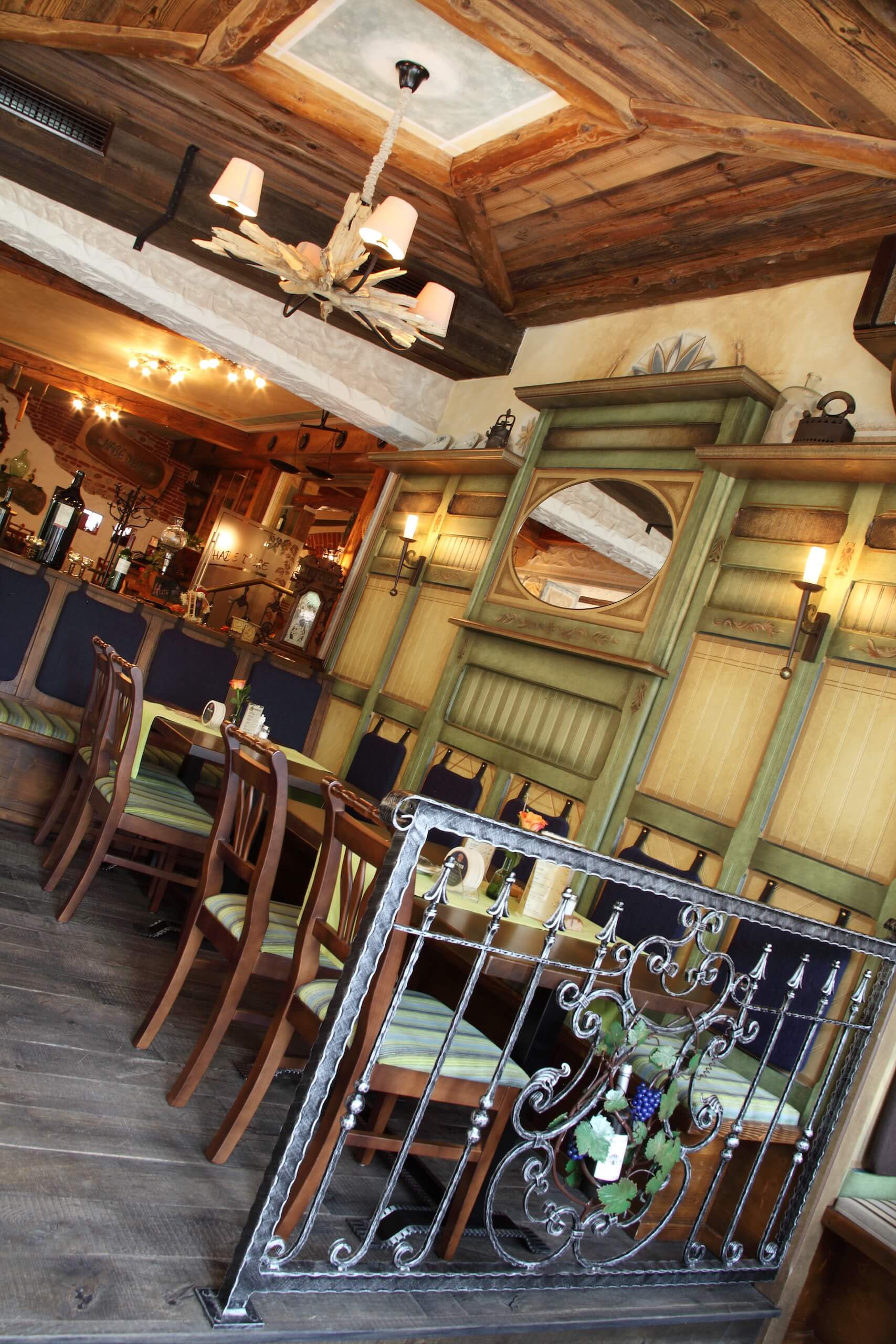 Gemütliches, rustikales Restaurant-Interieur mit hölzernen Elementen, dekorativen Lampen und einladendem Ambiente.