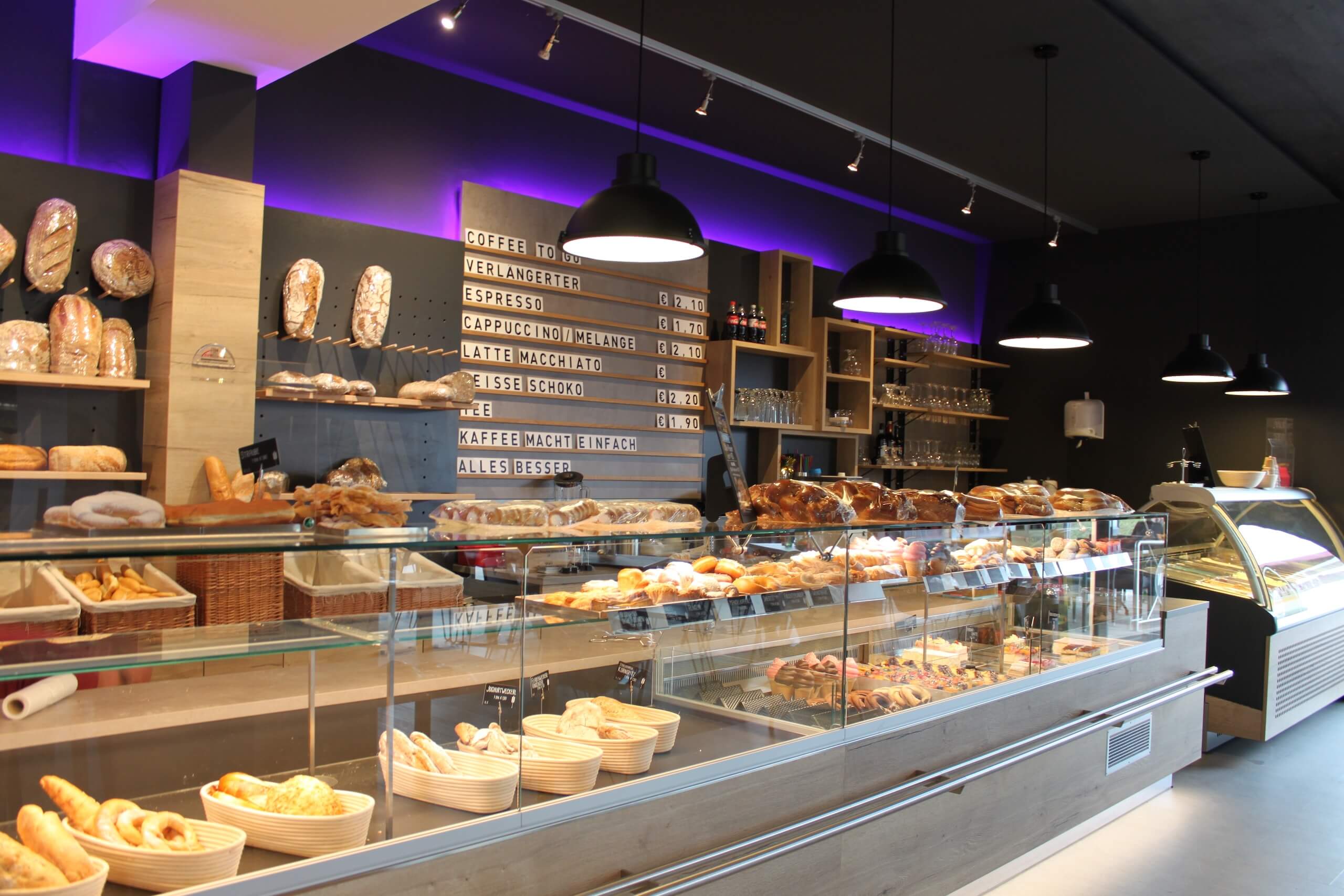 Gemütliche Bäckerei mit großer Auswahl an frischen Backwaren und Kaffee, modern eingerichtet mit ansprechender Beleuchtung.