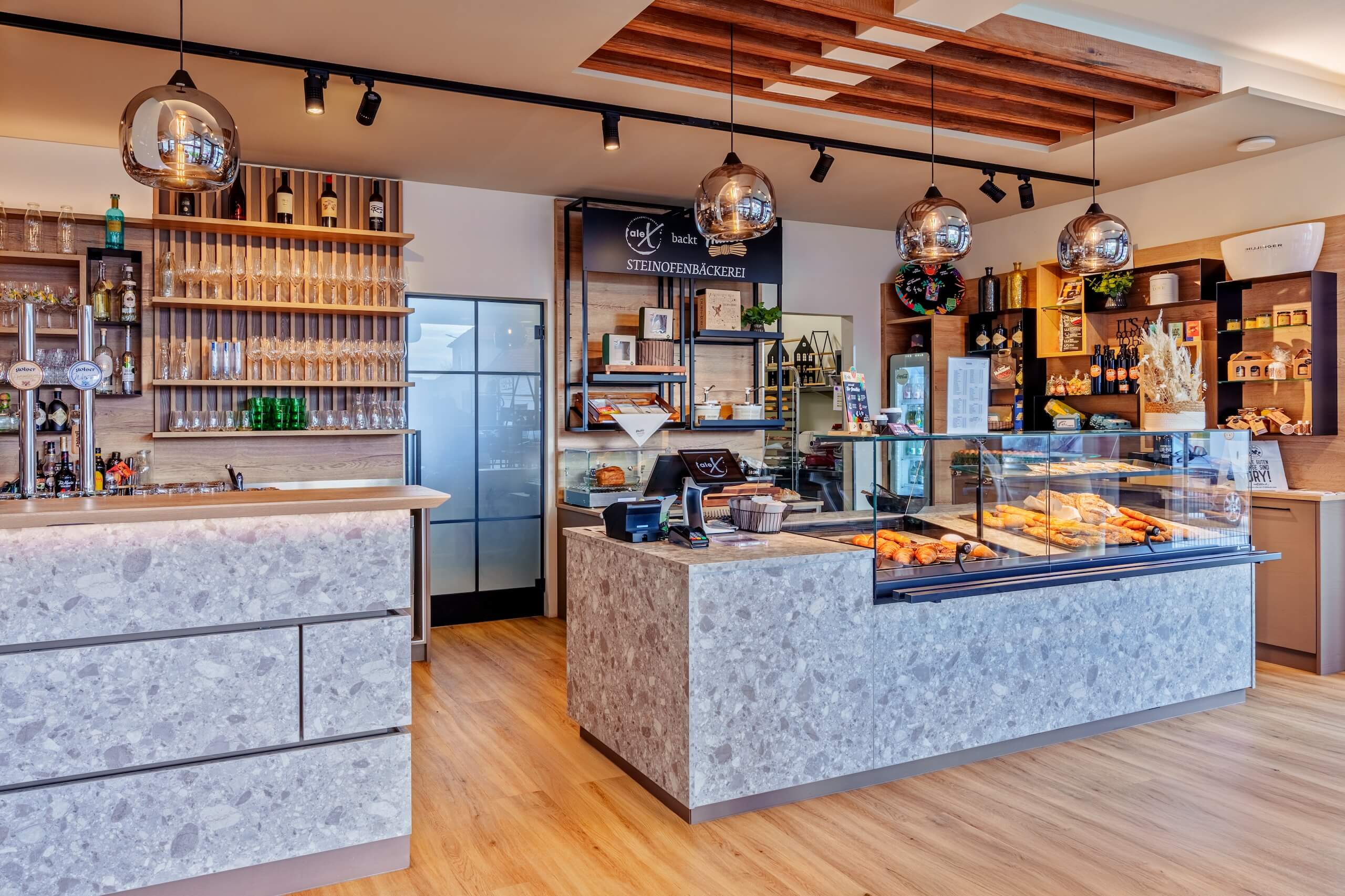 Moderne Bäckerei mit Steinofen, frischen Backwaren und einladendem Interieur für ein angenehmes Einkaufserlebnis.