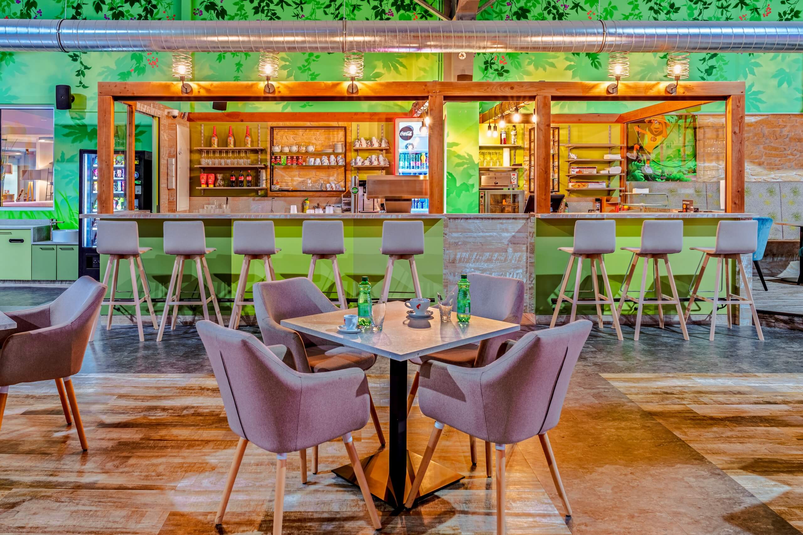 Moderne Café- und Bar-Inneneinrichtung mit stilvollen Sitzgelegenheiten und grünem Dekor.