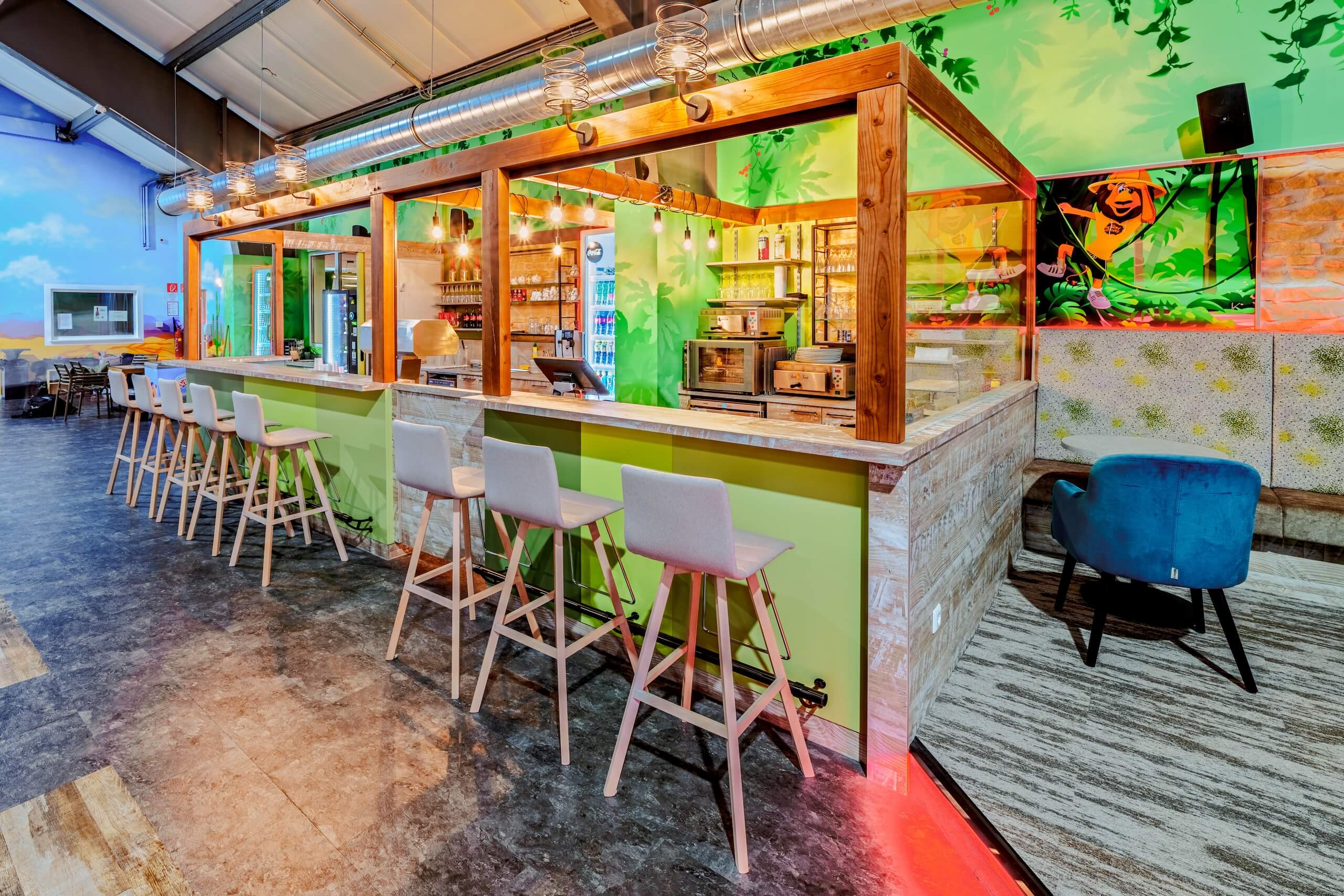 Moderne Bar in stilvollem Café mit grünen Akzenten und Holzelementen, helle Barhocker, gemütliche Atmosphäre.