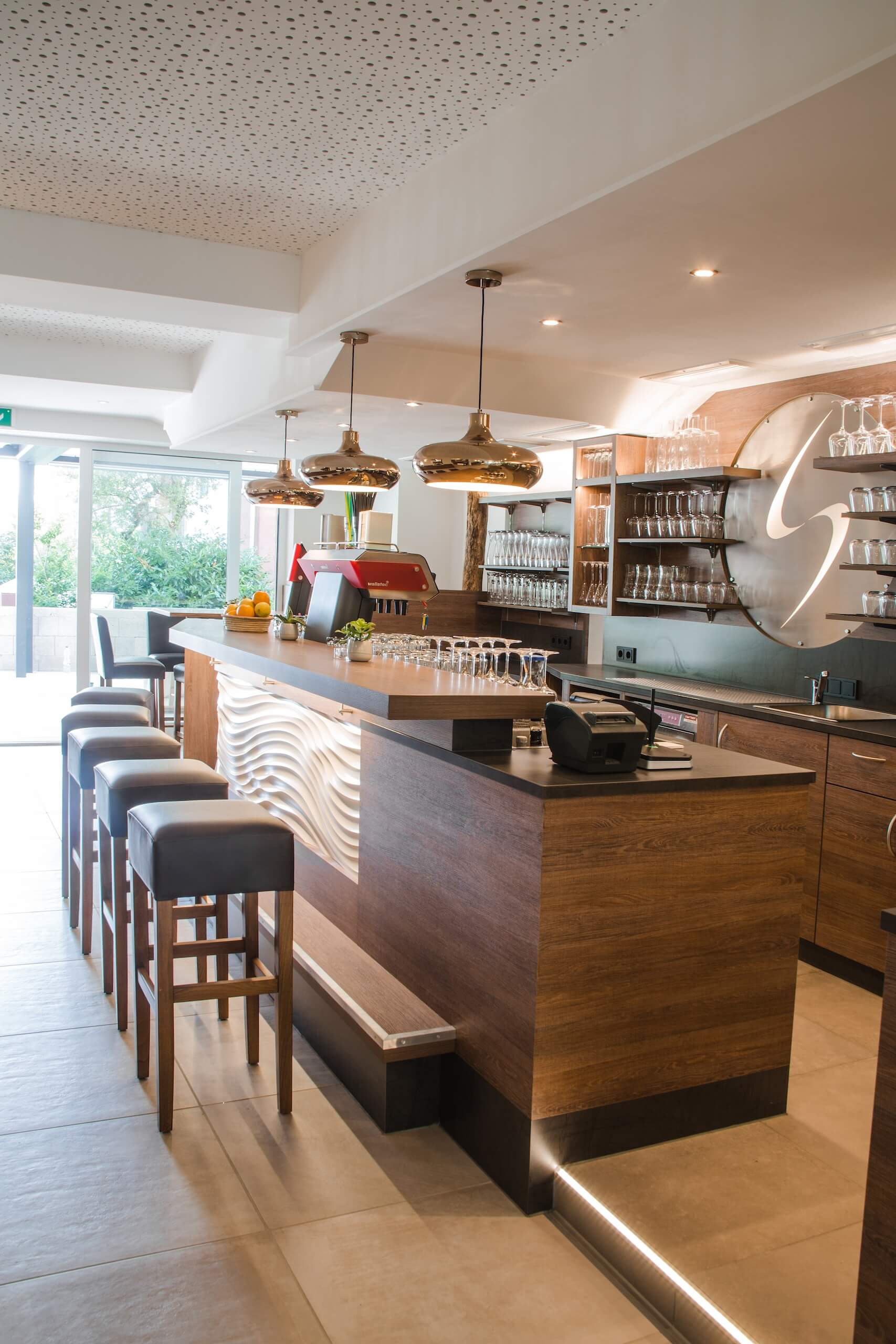 Moderne, stilvolle Bar mit gepolsterten Hockern, hölzernem Tresen und eleganter Beleuchtung für gemütliche Atmosphäre.