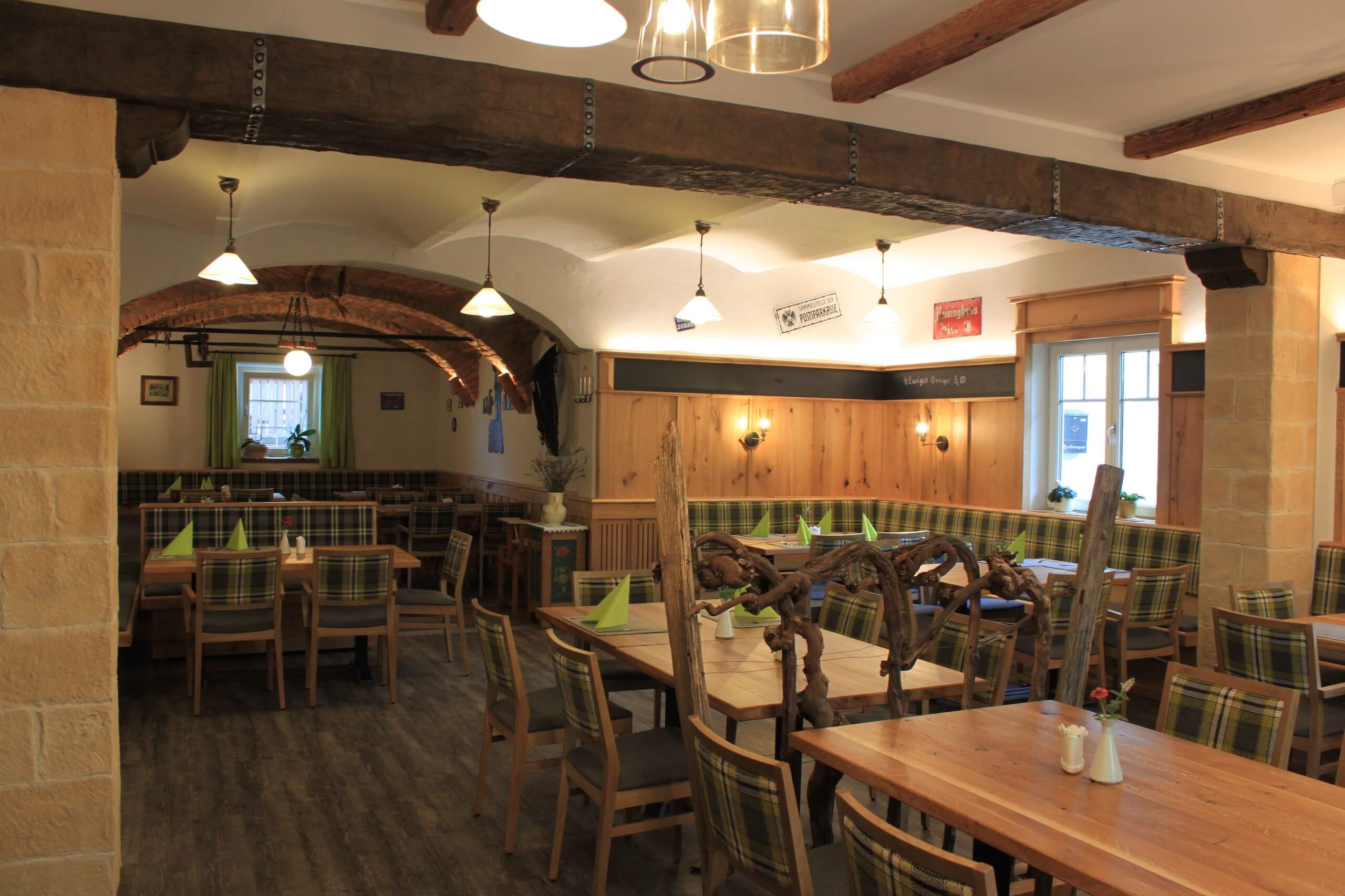 Gemütliches rustikales Restaurant mit holzverkleideten Wänden und einladender Beleuchtung, ideal für gesellige Abende.