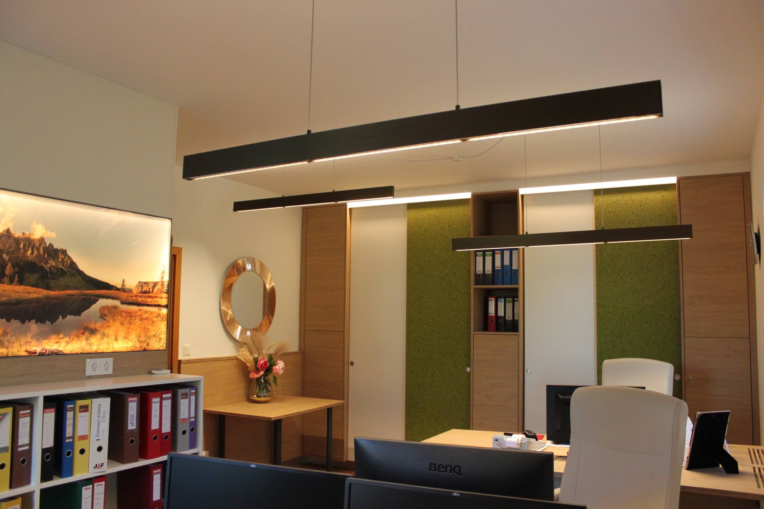 Modernes Büro mit Holzschränken, Pflanzenwand und eleganter Beleuchtung für produktives Arbeiten.