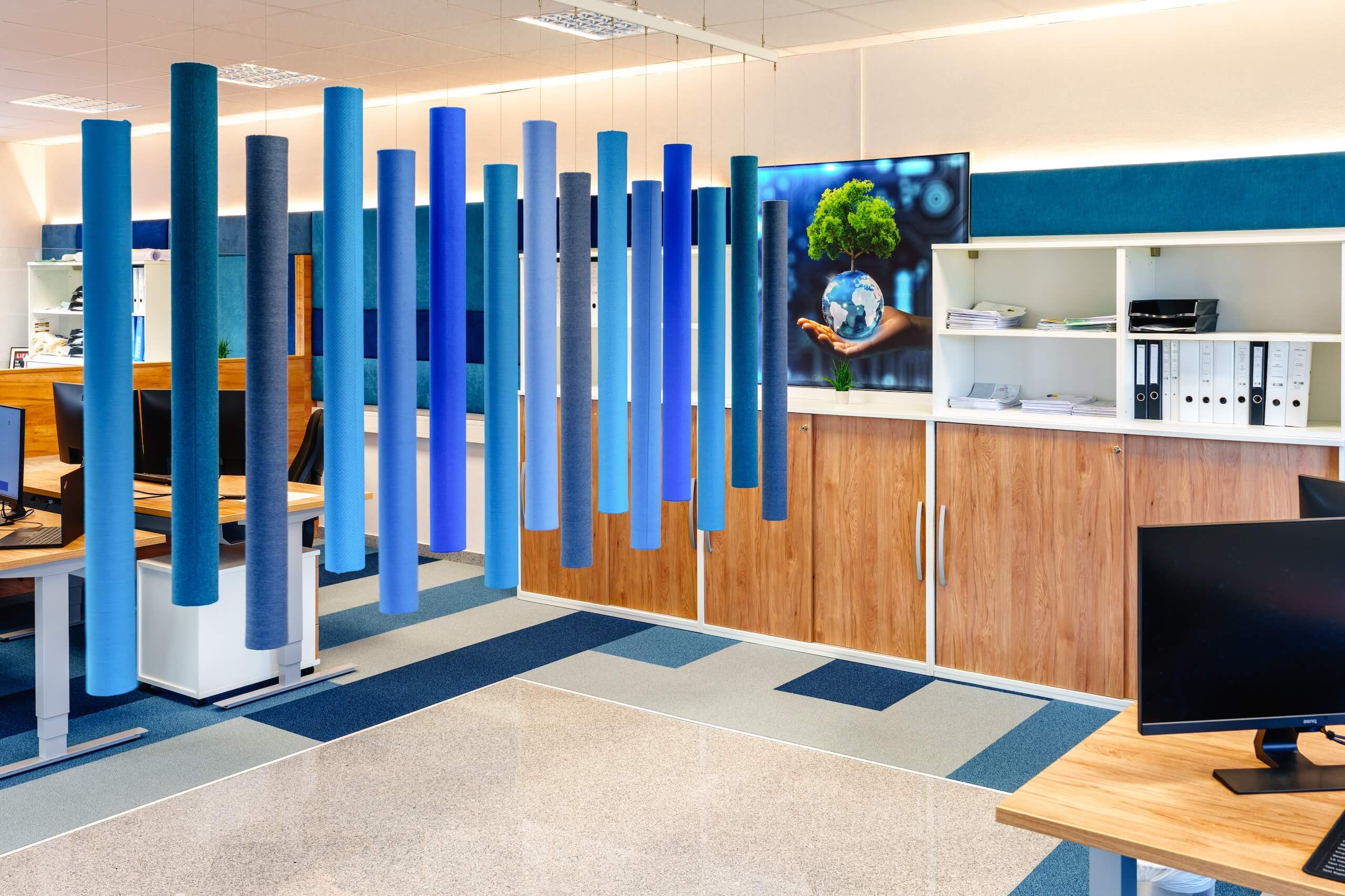 Modernes Büro mit Akustikpaneelen, Holzschränken und Bild von Nachhaltigkeit, gestaltet für kreative Arbeitsumgebung.